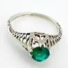 1920s sterling silver filigree ring with a round faceted emerald-green glass stone