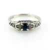 Sterling silver ring with a round blue sapphire, diamond accents and openwork shoulders