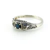 Sterling silver ring with a round blue sapphire, diamond accents and openwork shoulders