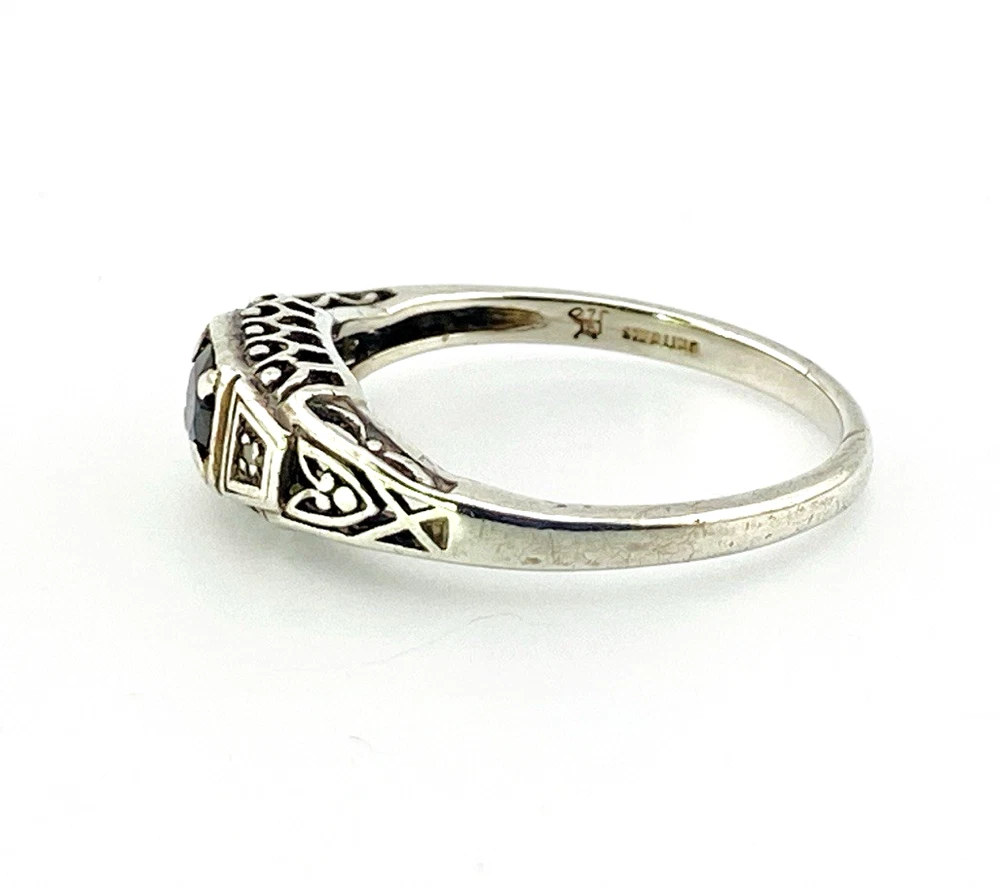 Sterling silver ring with a round blue sapphire, diamond accents and openwork shoulders