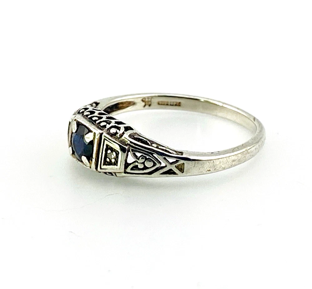 Sterling silver ring with a round blue sapphire, diamond accents and openwork shoulders