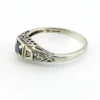 Sterling silver ring with a round blue sapphire, diamond accents and openwork shoulders