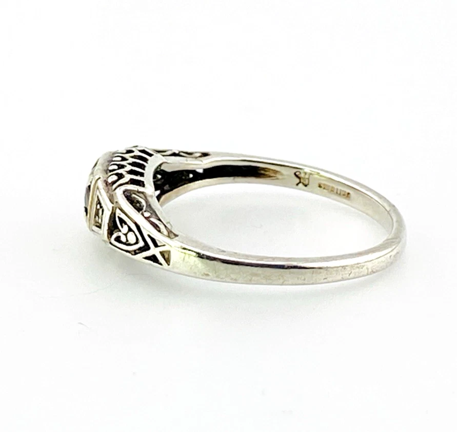Sterling silver ring with a round blue sapphire, diamond accents and openwork shoulders