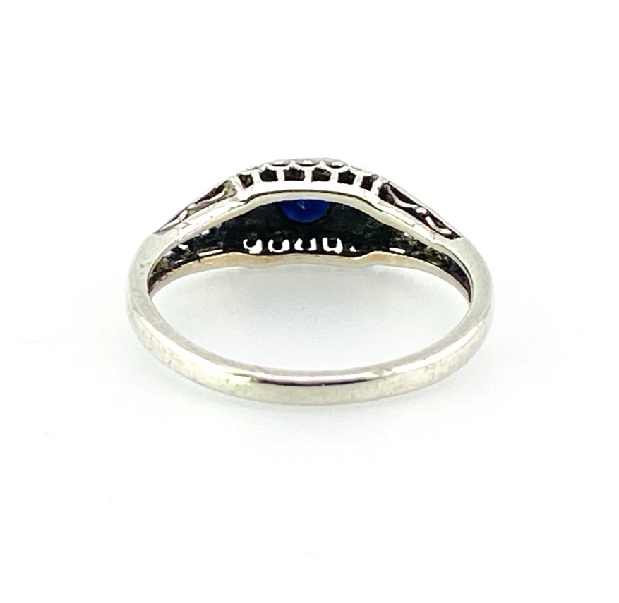 Sterling silver ring with a round blue sapphire, diamond accents and openwork shoulders