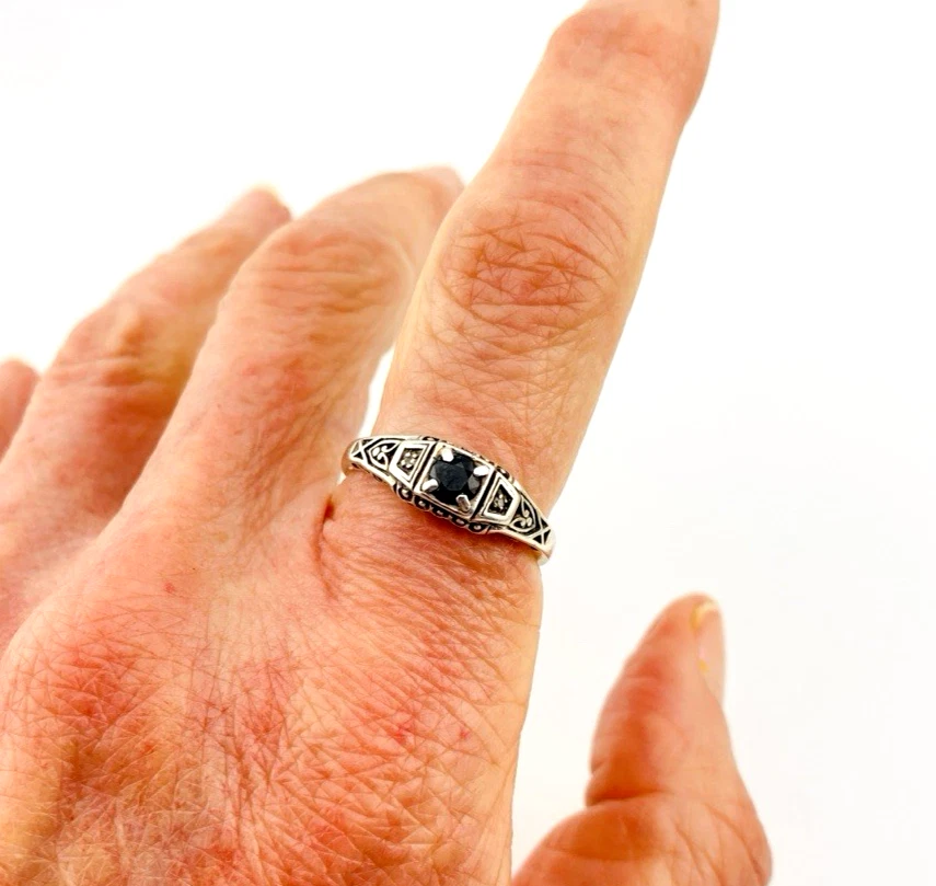 Sterling silver ring with a round blue sapphire, diamond accents and openwork shoulders