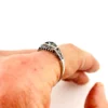 Sterling silver ring with a round blue sapphire, diamond accents and openwork shoulders