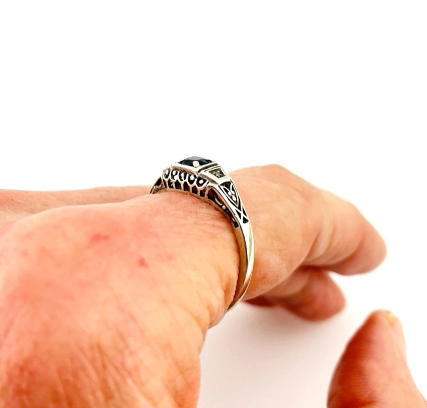 Sterling silver ring with a round blue sapphire, diamond accents and openwork shoulders
