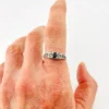 Sterling silver ring with a round blue sapphire, diamond accents and openwork shoulders