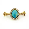 Late Victorian 14k gold brooch with oval turquoise, natural seed-pearl halo, and fleur-de-lis ends