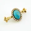 Late Victorian 14k gold brooch with oval turquoise, natural seed-pearl halo, and fleur-de-lis ends