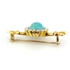 Late Victorian 14k gold brooch with oval turquoise, natural seed-pearl halo, and fleur-de-lis ends