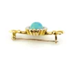 Late Victorian 14k gold brooch with oval turquoise, natural seed-pearl halo, and fleur-de-lis ends