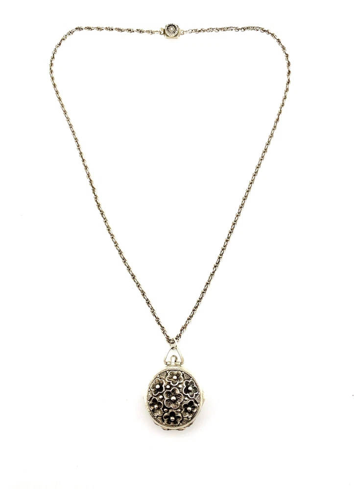 WWII-era sterling silver forget-me-not locket opened to reveal four original family photographs