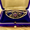 Circa 1950s gold-filled openwork clamper bracelet with rectangular amethyst glass stone and scroll decoration
