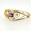 Circa 1950s gold-filled openwork clamper bracelet with rectangular amethyst glass stone and scroll decoration