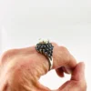 Oval natural opal surrounded by tiered blue sapphires in a white gold plated sterling silver princess cluster ring
