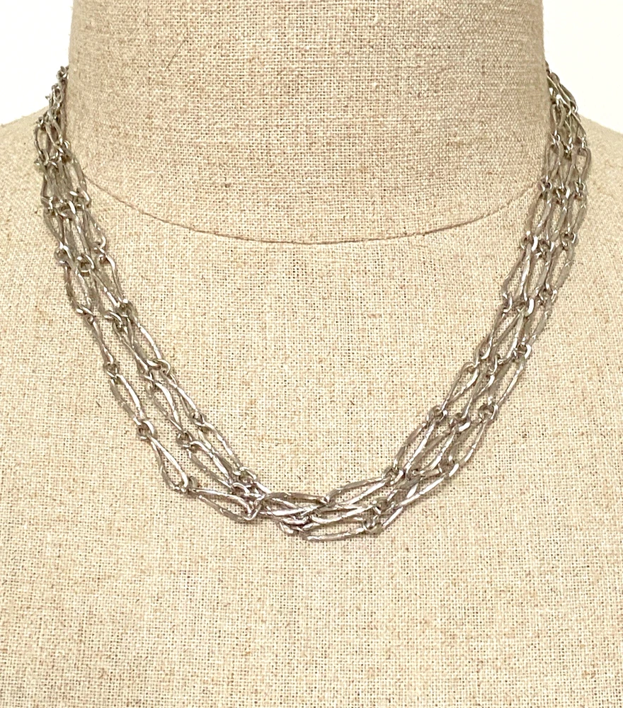 Long 800 silver guard chain with ribbon-bound sheaf links, swivel dog clip, and spring ring, shown doubled on a mannequin