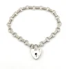 Slender sterling silver gate-link bracelet with ribbed bars, open connectors, and a heart padlock clasp