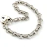 Slender sterling silver gate-link bracelet with ribbed bars, open connectors, and a heart padlock clasp
