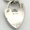 Slender sterling silver gate-link bracelet with ribbed bars, open connectors, and a heart padlock clasp