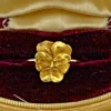 Antique Art Nouveau 10K yellow gold pansy-face Green Man stick-pin conversion ring, circa 1900–1905 presented in an antique jewelry box for illustration