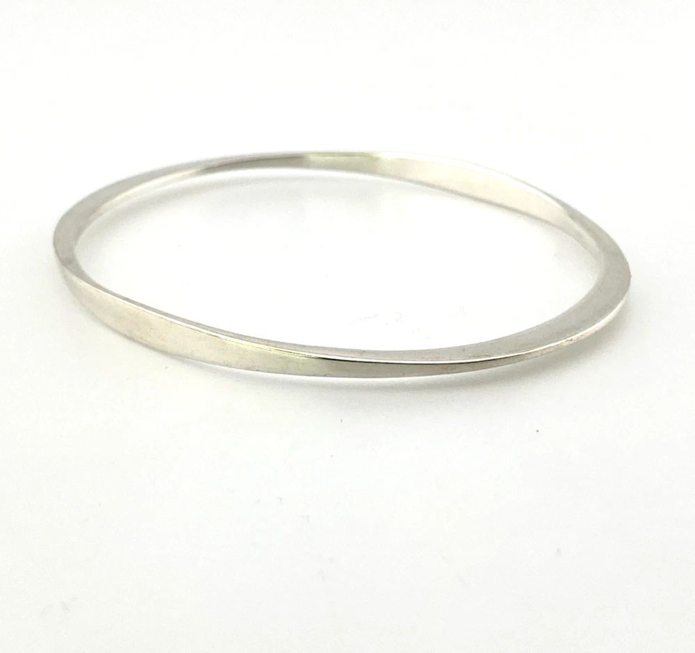 Sculptural Mexican silver bangle narrowing from 5mm to 2mm along the sides