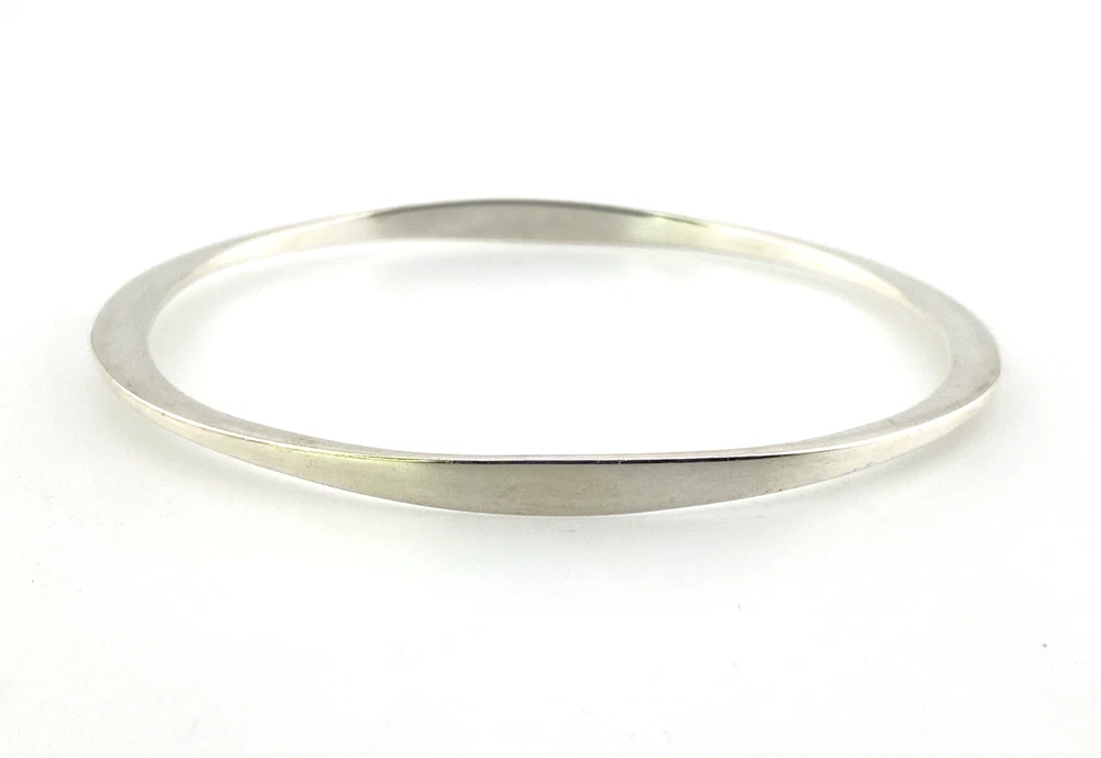 Sculptural Mexican silver bangle narrowing from 5mm to 2mm along the sides