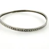 Eight-inch sterling silver crescent-pattern bangle showing its slightly irregular round shape