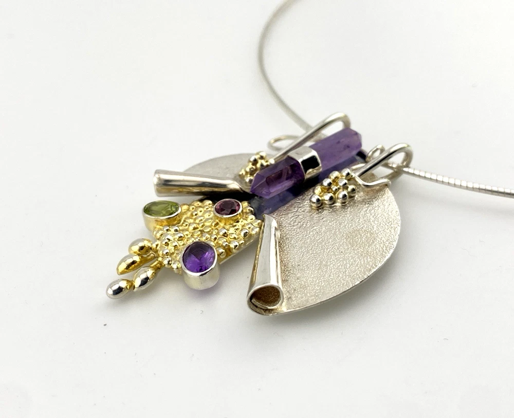 Showing sculptural depth on late 1980s Modernist sterling silver and gold-vermeil Art-to-Wear pendant necklace with amethyst, garnet and peridot