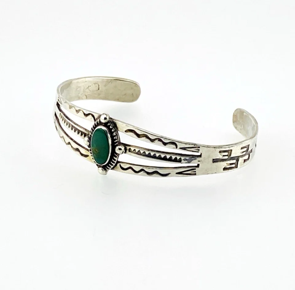 Antique Navajo sterling silver cuff bracelet with turquoise stone, hand-stamped cactus and arrow motifs, and aged silver patina, Fred Harvey era.