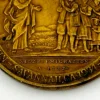 1934 United Lutheran Church bronze medal showing a religious figure facing an emigrant family beneath an angel, with Savannah convention inscriptions.