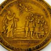 1934 United Lutheran Church bronze medal showing a religious figure facing an emigrant family beneath an angel, with Savannah convention inscriptions.
