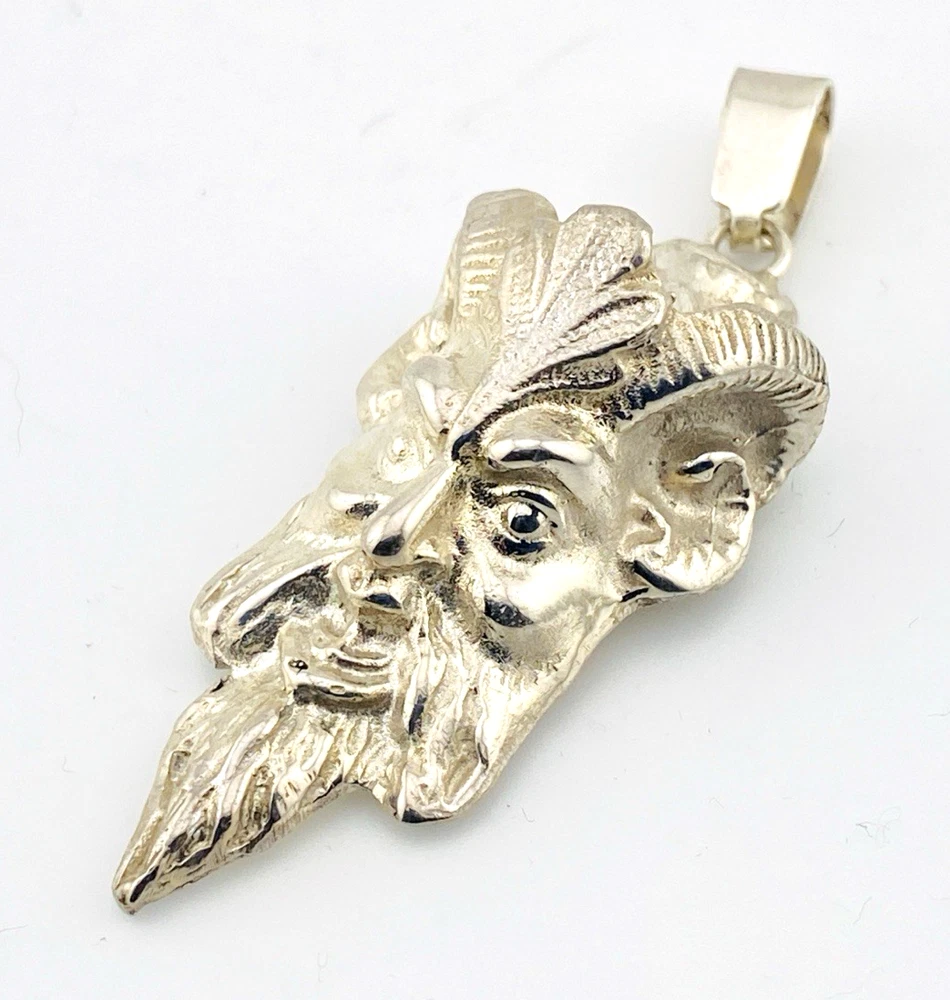 Sterling silver pendant showing a bearded mythological figure with curled ram horns, an acanthus leaf between the horns, a pointed beard, and a broad bail.