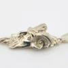 Sterling silver pendant showing a bearded mythological figure with curled ram horns, an acanthus leaf between the horns, a pointed beard, and a broad bail.