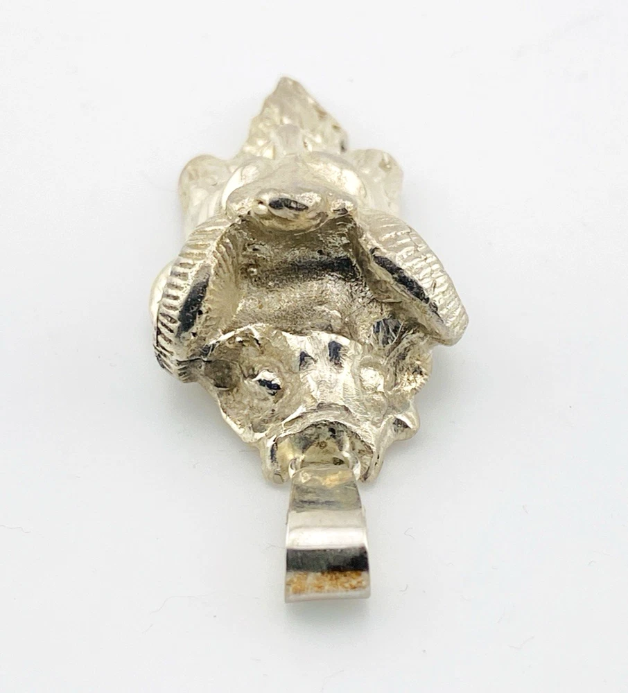 Sterling silver pendant showing a bearded mythological figure with curled ram horns, an acanthus leaf between the horns, a pointed beard, and a broad bail.