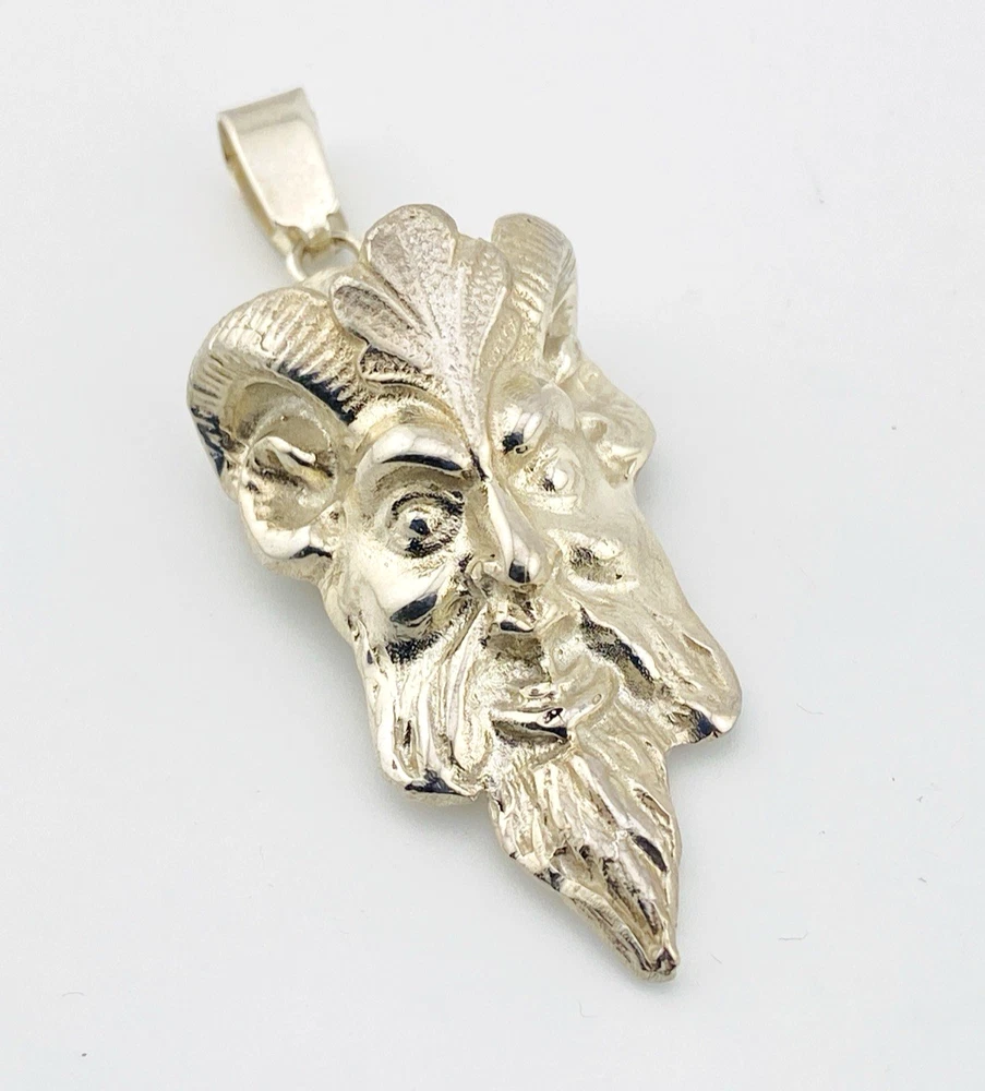 Sterling silver pendant showing a bearded mythological figure with curled ram horns, an acanthus leaf between the horns, a pointed beard, and a broad bail.