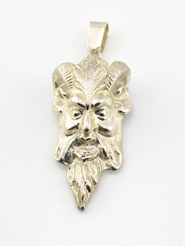 Sterling silver pendant showing a bearded mythological figure with curled ram horns, an acanthus leaf between the horns, a pointed beard, and a broad bail.