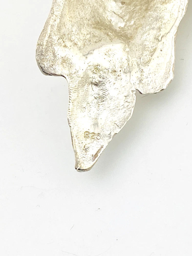 Sterling silver pendant showing a bearded mythological figure with curled ram horns, an acanthus leaf between the horns, a pointed beard, and a broad bail.