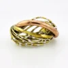 Sculptural unisex cuff bracelet with intertwined brass wires, a textured copper arc, silver-colored molten-drop accents, and rounded ball terminals.