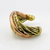 Sculptural unisex cuff bracelet with intertwined brass wires, a textured copper arc, silver-colored molten-drop accents, and rounded ball terminals.