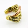 Sculptural unisex cuff bracelet with intertwined brass wires, a textured copper arc, silver-colored molten-drop accents, and rounded ball terminals.
