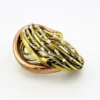 Sculptural unisex cuff bracelet with intertwined brass wires, a textured copper arc, silver-colored molten-drop accents, and rounded ball terminals.