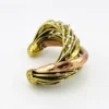 Sculptural unisex cuff bracelet with intertwined brass wires, a textured copper arc, silver-colored molten-drop accents, and rounded ball terminals.