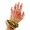 Sculptural unisex cuff bracelet with intertwined brass wires, a textured copper arc, silver-colored molten-drop accents, and rounded ball terminals.