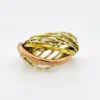 Sculptural unisex cuff bracelet with intertwined brass wires, a textured copper arc, silver-colored molten-drop accents, and rounded ball terminals.