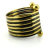 Wide cuff bracelet with alternating golden brass and near-black copper bands, four round brass finials, and small areas of wear to the darkened finish.