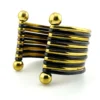 Wide cuff bracelet with alternating golden brass and near-black copper bands, four round brass finials, and small areas of wear to the darkened finish.