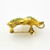 Gold-plated sterling silver bee brooch with a green gemstone-set body, clear cubic zirconia accent, raised patterned wings, and textured legs.