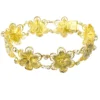 Pale gold-over-silver bracelet with eight six-petal filigree flowers, raised bead centers, and paired connecting links.