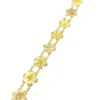 Pale gold-over-silver bracelet with eight six-petal filigree flowers, raised bead centers, and paired connecting links.